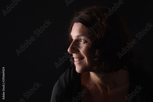 portrait of a smiling woman on black background