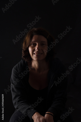 portrait of a woman sitting on black background