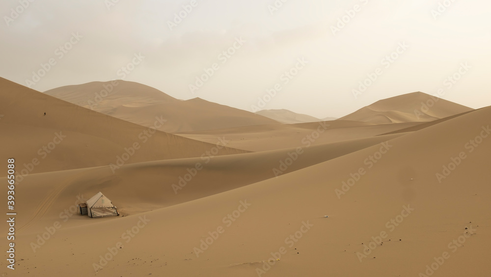 sand dunes in the desert with human settlement