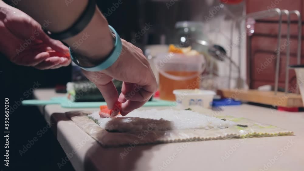 sushi cooking process. man prepares sushi. the guy puts the filling for the rolls. cooking food at home. sushi cooking process. man prepares sushi. the guy puts the filling for the rolls. cooking food at home.