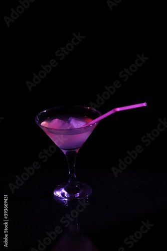 Cocktail with ice in a transparent glass on a black background