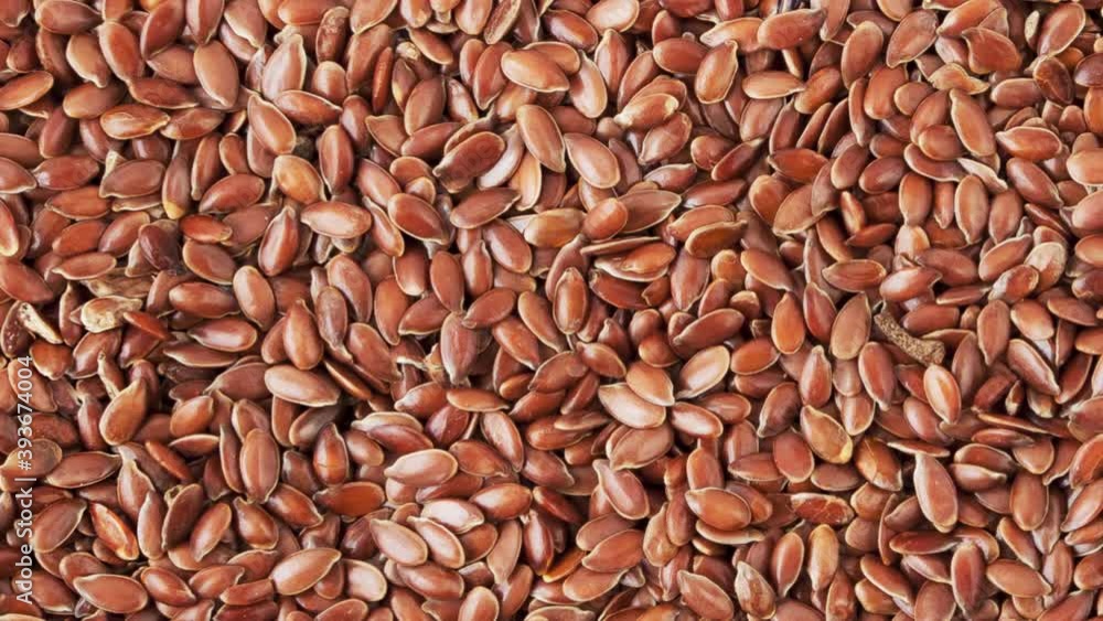 Background and texture of rotating flax seeds. View from above Background and texture of rotating flax seeds. View from above