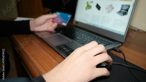Young woman browsing ecommerce store on a laptop for web shopping,credit card
