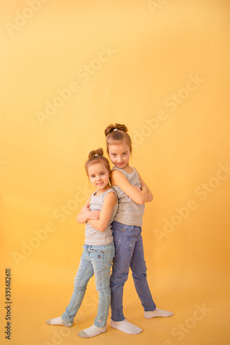 Image Of Two Happy Sisters Having Fun on yellow background