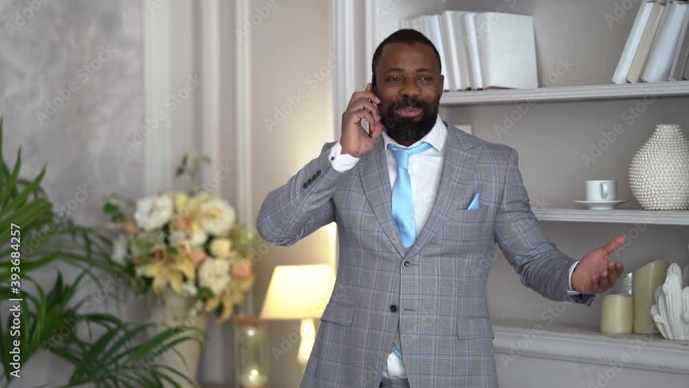 rich man is communicating by mobile phone in hall of his apartment with stylish interior rich man is communicating by mobile phone in hall of his apartment with stylish interior