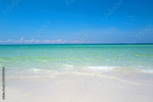 Fototapeta Naklejka Na Ścianę i Meble -  Soft blue ocean wave on clean sandy beach. Beautiful beach with blue sea water. Lagoon and white sandy beach.
