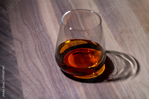 a glass of whiskey on walnut wood texture close-up