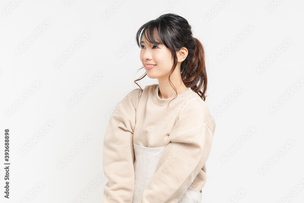 白い背景の前に立ってポーズをとる若い女性 白い背景の前に立ってポーズをとる若い女性