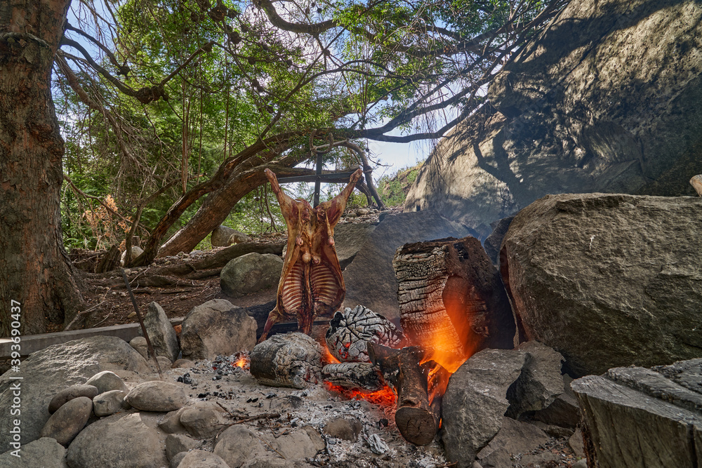 rustic lamb barbecue bbq over open fire in Patagonia, Argentina, South America. Asado is a Gaucho traditon with cooking on open flame rustic lamb barbecue bbq over open fire in Patagonia, Argentina, South America. Asado is a Gaucho traditon with cooking on open flame