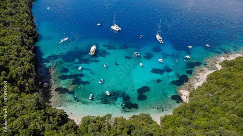 Aerial drone photo of iconic sandy beach and floating boats in Sivota, Epirus, Greece