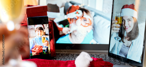 Family online video conference  christmas greetings. Virtual call through screen of laptop  tablet  mobile phone. Glass of champagne  gift. Remote conversation with mom  wife  children.Home isolation