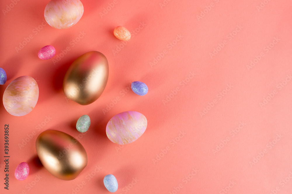 Trendy Easter background with Gold and colored Easter eggs on a light coral color background with copy space. Top view still life. Easter concept. Trendy Easter background with Gold and colored Easter eggs on a light coral color background with copy space. Top view still life. Easter concept.