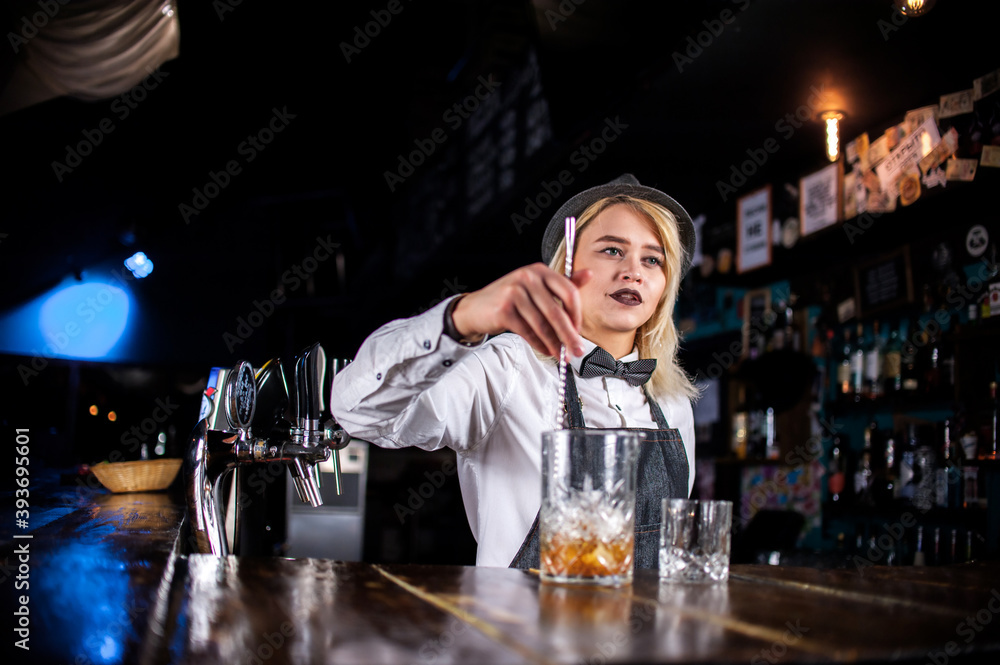Girl barman creates a cocktail in the porterhouse
