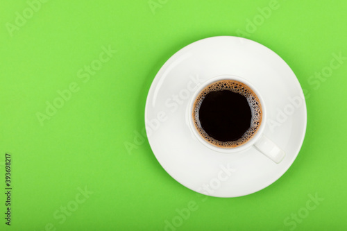Full white espresso coffee cup over green