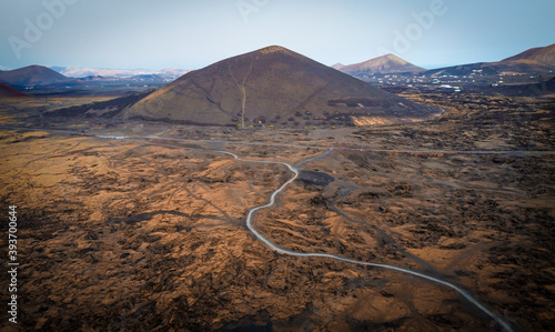 Aerial view of black and brown volcano with a road. photo