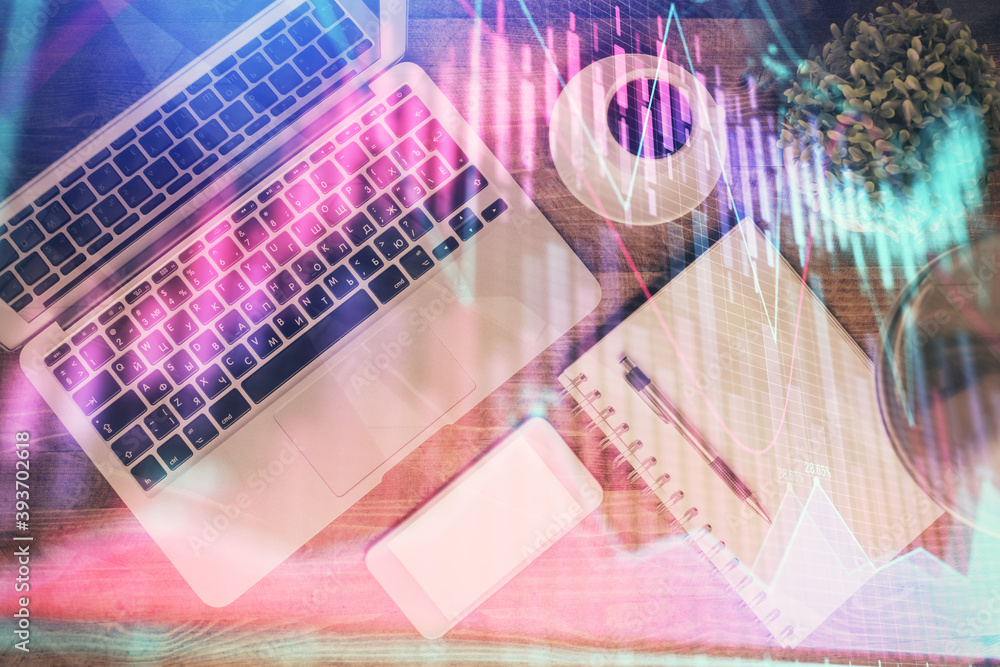 Financial market graph and top view computer on the desktop background. Double exposure. Investment concept. Financial market graph and top view computer on the desktop background. Double exposure. Investment concept.