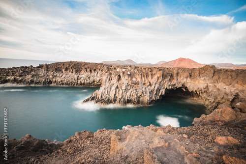 Landscape of the volcanic coast of Los Hervideros with sea caves where the waves break.