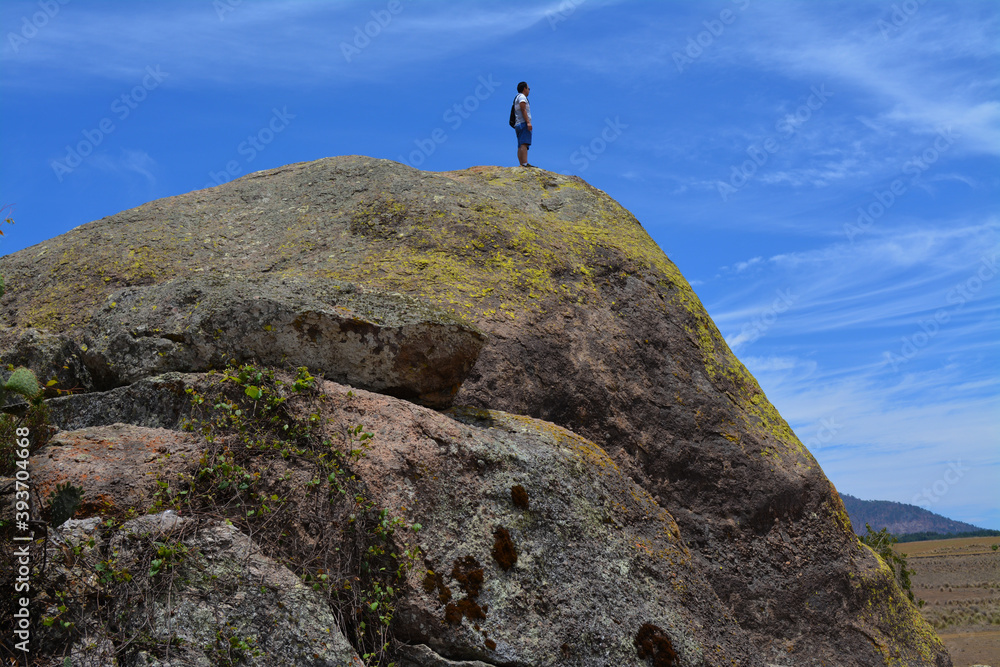 Persona hombre mirando el horizonte en la cima de roca gigante en el parque natural 