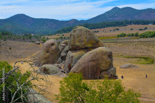 Vista panorámica de Parque Natural Las Piedrotas en Tapalpa Jalisco Mexico, rocas gigantes sobre pastizal, al fondo bosque. montañas y cielo azul © Luis Macedo