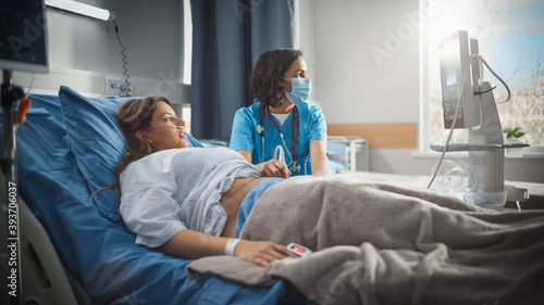 Hospital Ward: Beautiful Pregnant Hispanic Woman Getting Sonogram / Ultrasound Screening / Scan, Female Latin Obstetrician Wearing Face Mask Checks Picture of the Healthy Baby on the Computer Screen photo
