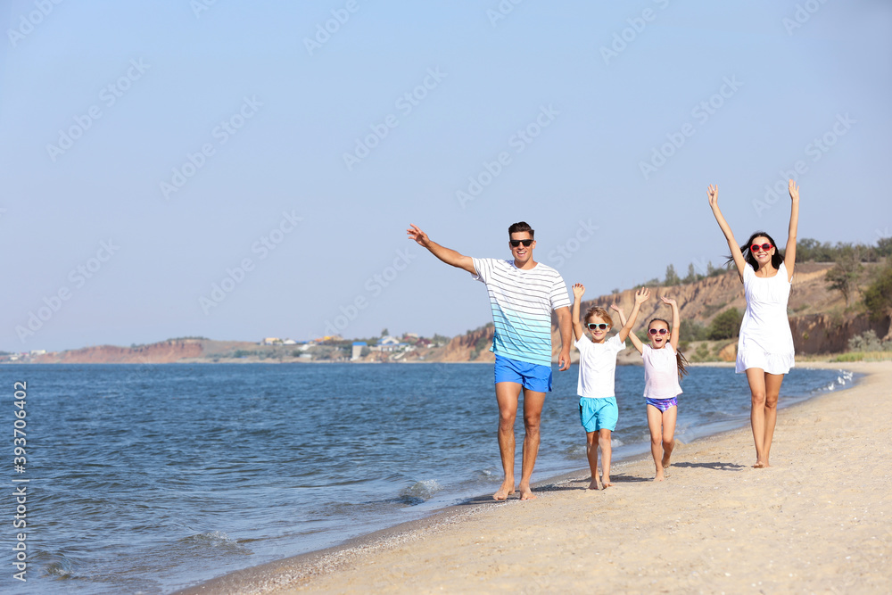 Happy family walking on sandy beach near sea. Summer holidays Happy family walking on sandy beach near sea. Summer holidays