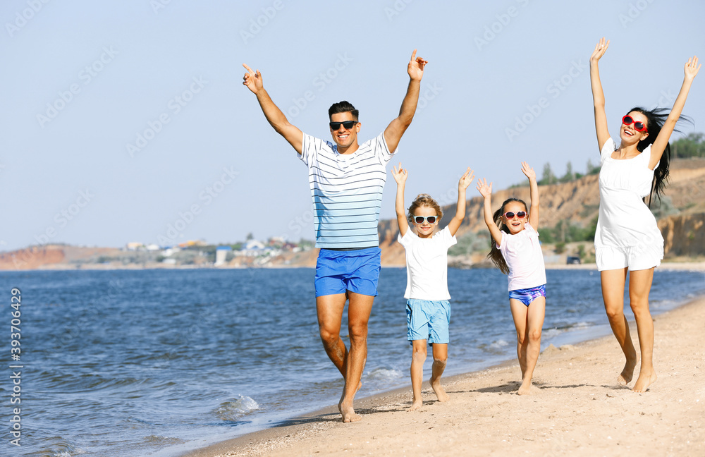 Happy family walking on sandy beach near sea. Summer holidays Happy family walking on sandy beach near sea. Summer holidays