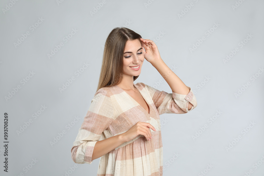 Young woman wearing stylish dress on light grey background Young woman wearing stylish dress on light grey background