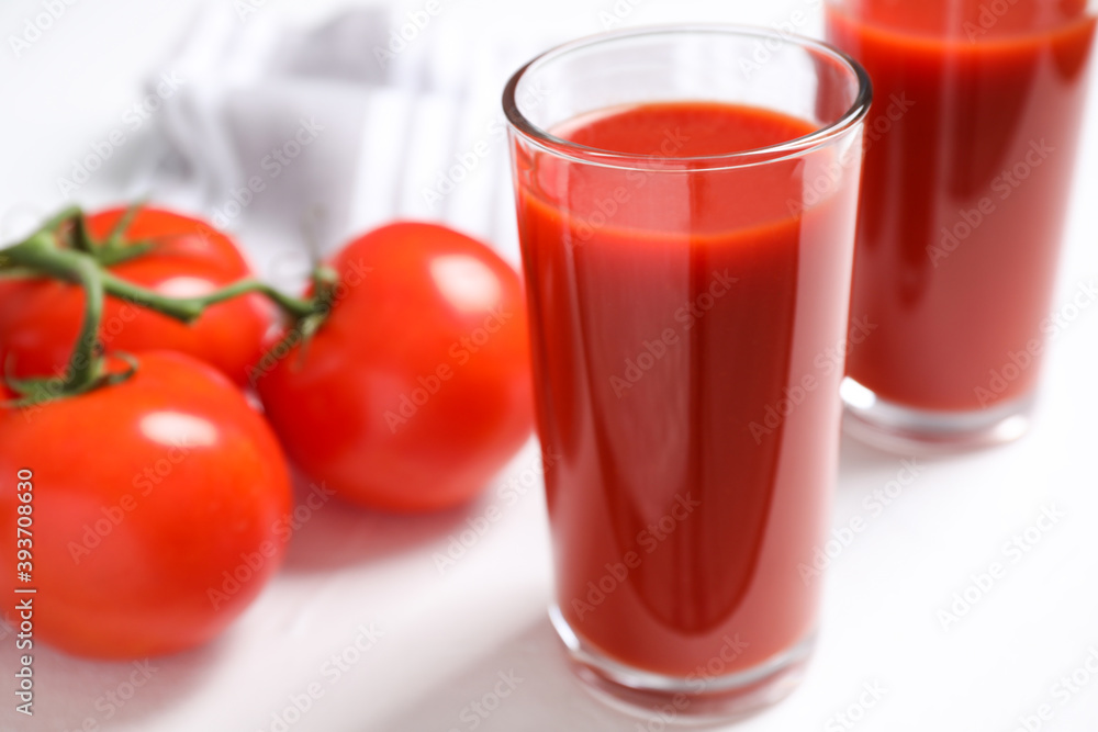 Delicious fresh tomato juice on white table, closeup Delicious fresh tomato juice on white table, closeup