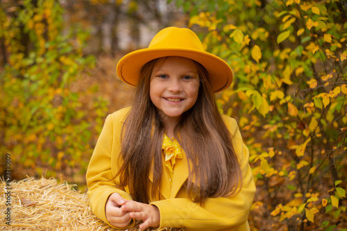 portrait of cute beautiful teenage brunette girl in an orange hat  dress and coat. autumn  Cosiness