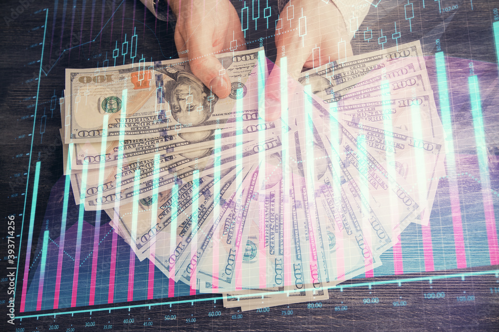 Multi exposure of financial graph drawing hologram and USA dollars bills and man hands. Analysis concept. Multi exposure of financial graph drawing hologram and USA dollars bills and man hands. Analysis concept.