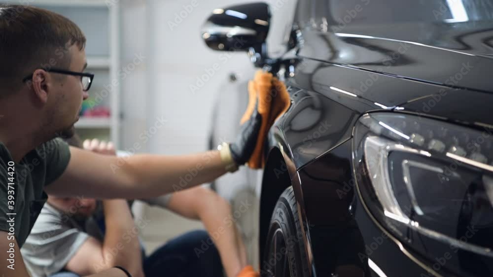 Two specialist dries the car from moisture, car washing at detailing service. Two specialist dries the car from moisture, car washing at detailing service.