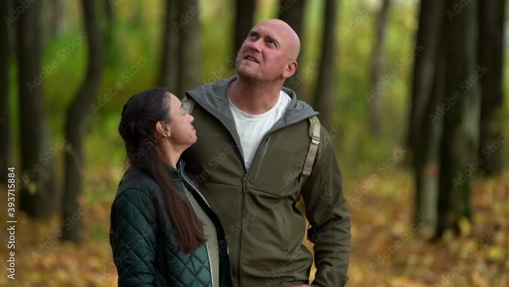 loving man and woman are embracing standing in picturesque forest at autumn day, admiring colorful trees and landscape loving man and woman are embracing standing in picturesque forest at autumn day, admiring colorful trees and landscape