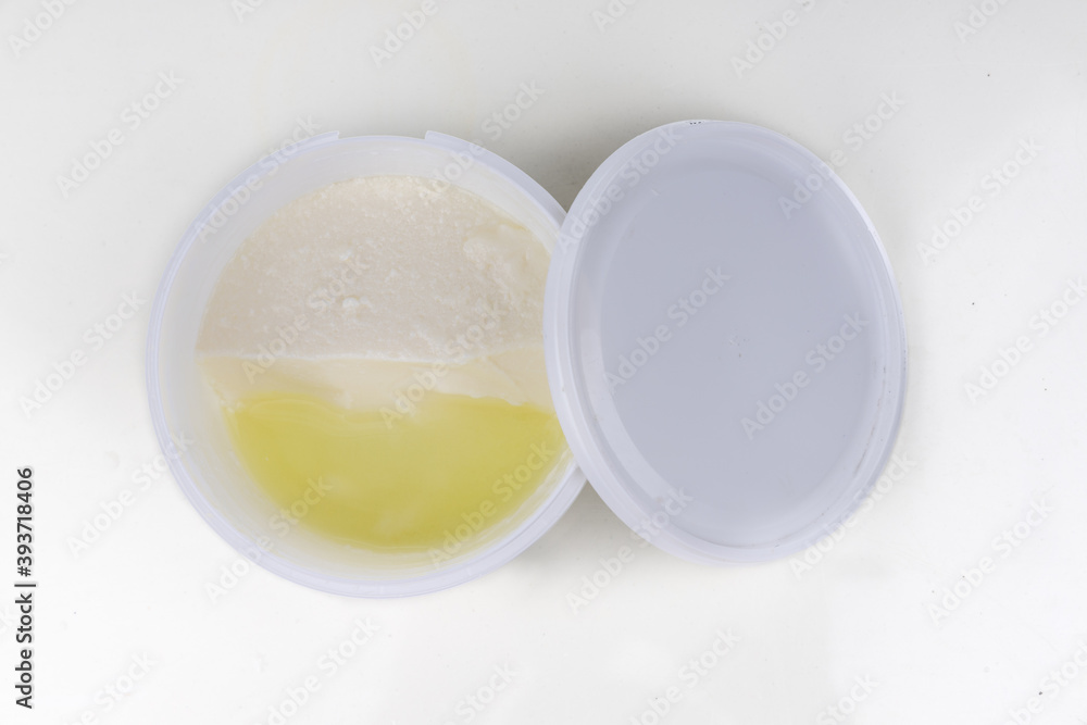 Layer of whey protein formed on top of packaged yogurt after opening in white background. Layer of whey protein formed on top of packaged yogurt after opening in white background.