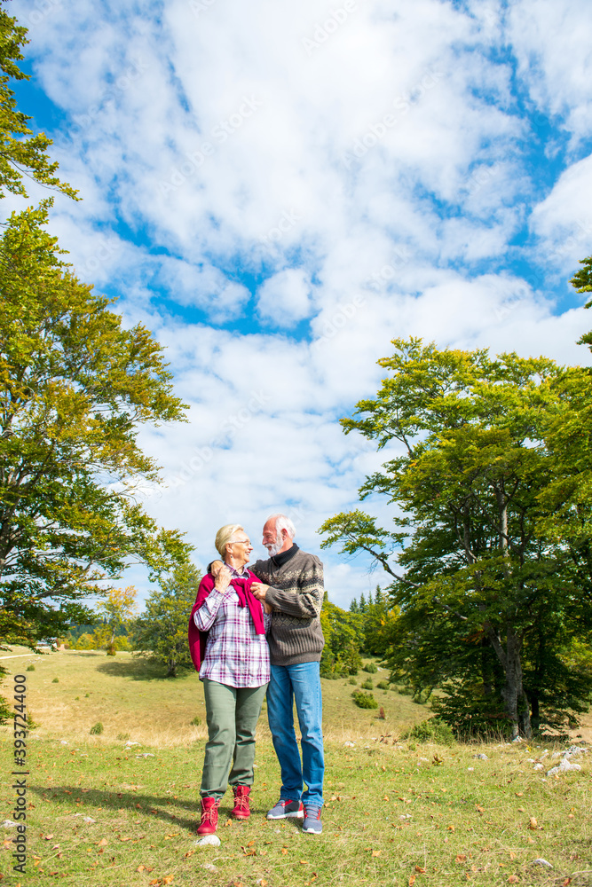 Fototapeta premium Senior couple on a walk in an autumn nature.