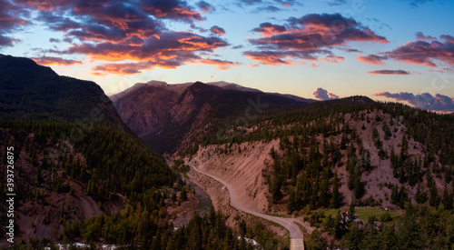 Aerial Panoramic View of a Scenic Dirt Road towards Gold Bridge in the Valley surrounded by Canadian Mountain Landscape. Dramatic Sunset Sky. Taken near Lillooet, British Columbia, Canada.