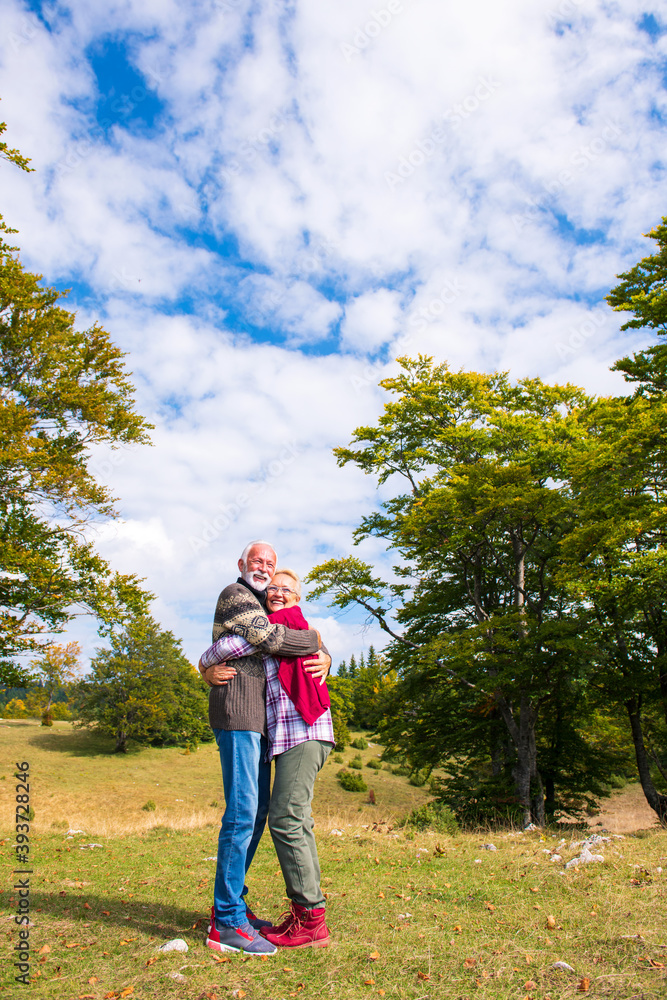 Elderly couple embracing in autumn park. Enjoying in love. Elderly couple embracing in autumn park. Enjoying in love.