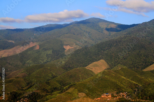 Beautiful landscape view of mountain and small village stay near entrance hill with blue sky and cloud in north of Thailand. Beauty in nature and live with natural  photo