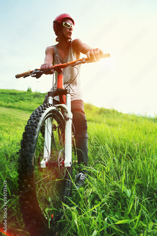 Young Caucasian man jumping on a mountain bike from a springboard in the forest. Young Caucasian man jumping on a mountain bike from a springboard in the forest.