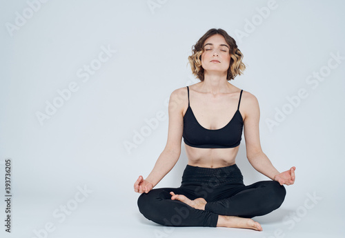 Woman with crossed legs meditate while sitting on the floor of yoga asana