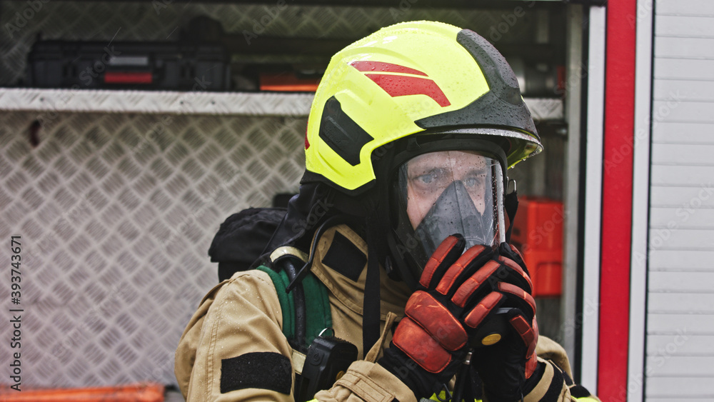 Close up, portrait of firefighter wearing gas mask in front of the burning house. High quality photo Close up, portrait of firefighter wearing gas mask in front of the burning house. High quality photo