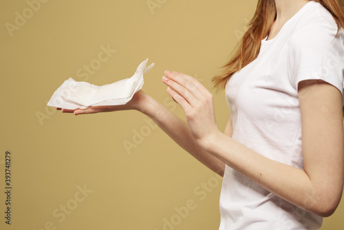 Wallpaper Mural Girl with a clean pad in her hand on a beige background cropped view of menstruation critical days hygiene Torontodigital.ca