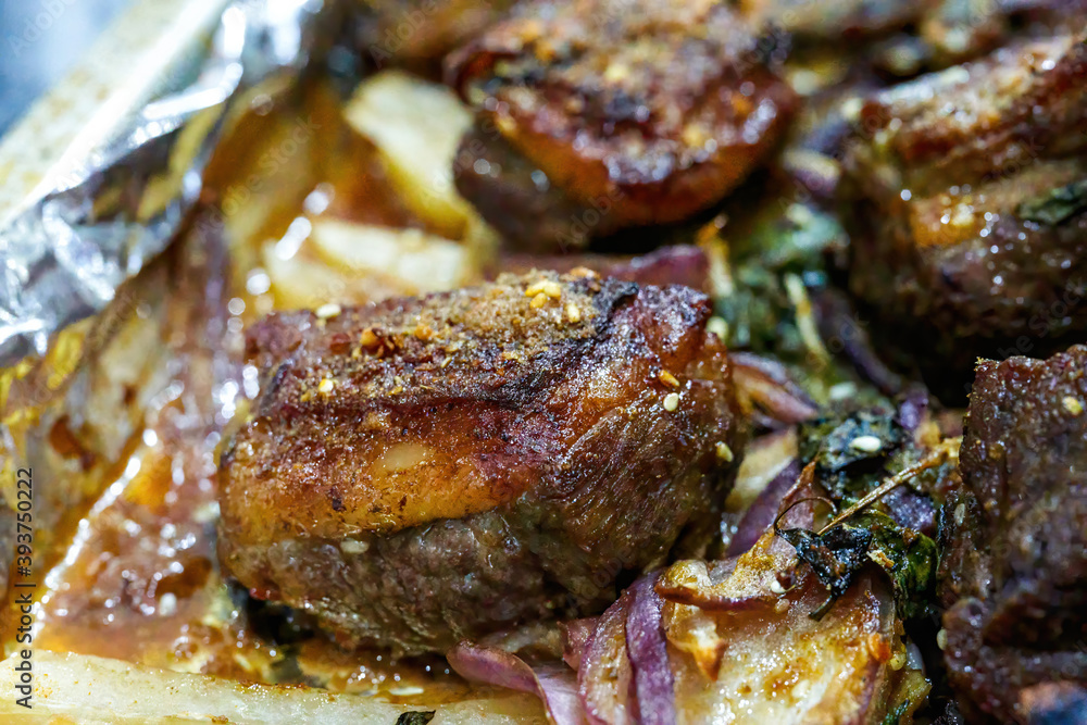 Closeup of a plate of grilled lamb chops with onions and potatoes