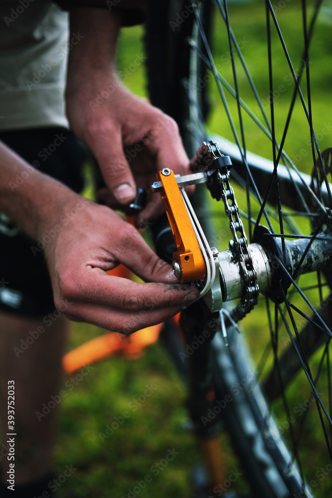 Young male cyclist repairs his bike in the mountains. Young male cyclist repairs his bike in the mountains.