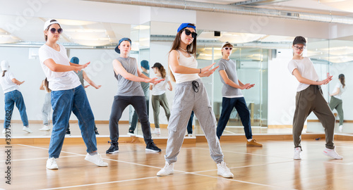 Fototapeta Naklejka Na Ścianę i Meble -  Focused teenage hip hop dancers doing dance workout during group class