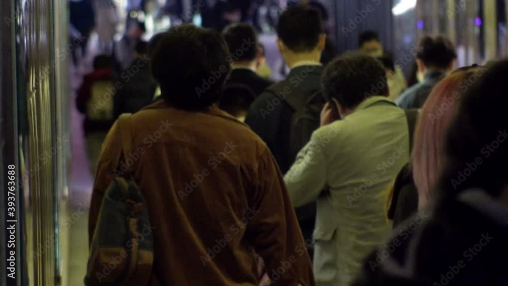 TOKYO, JAPAN : Crowd of people at the street in night time rush hour. Back shot of people walking to train station after work. Japanese city life style, business and work concept shot. Slow motion. TOKYO, JAPAN : Crowd of people at the street in night time rush hour. Back shot of people walking to train station after work. Japanese city life style, business and work concept shot. Slow motion.
