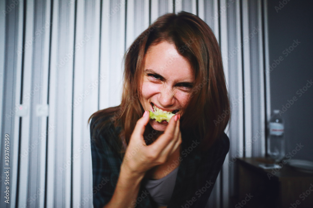 Young caucasian woman eating a green apple at home Young caucasian woman eating a green apple at home