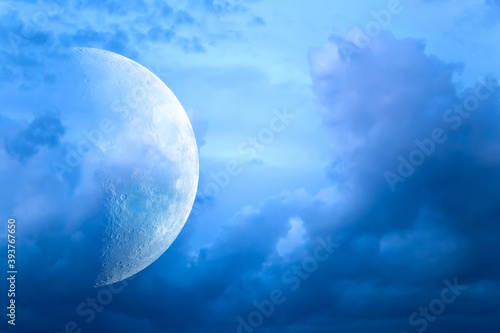 The moon in the disturbing night sky. Blue storm clouds.