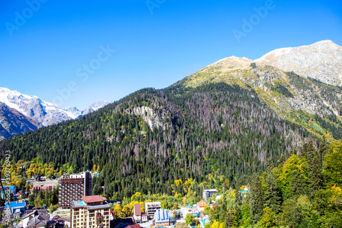 A picturesque view of the Caucasus Mountains, the village of Dombai and a monument to Soviet modernism - the unfinished hotel 