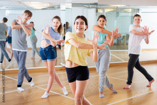Dancing group of five teenagers practicing new dance in studio