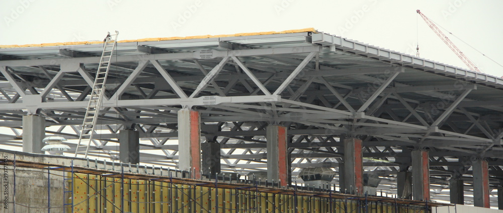 An old steel metal farm. structure of metal structure of frame-type industrial building. Lightweight metal frame construction. An old steel metal farm. structure of metal structure of frame-type industrial building. Lightweight metal frame construction.